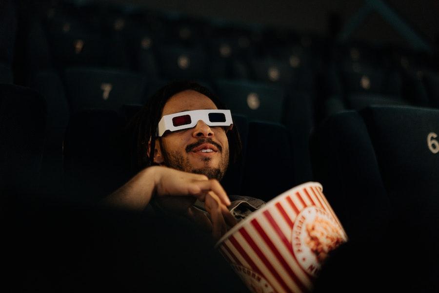 Человек, сидящий в кинотеатре и смотрящий фильм
